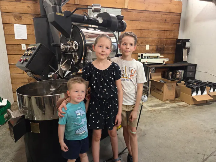 Children standing in front of the coffee roaster