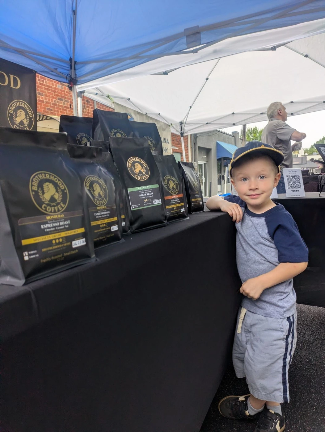 Child beside the Brotherhood Coffee market display