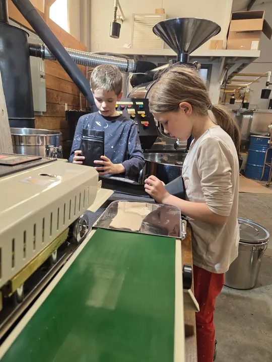 Children helping package coffee bags in the roastery