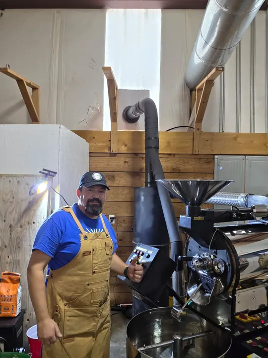 Brotherhood Coffee roaster standing beside the roasting machine